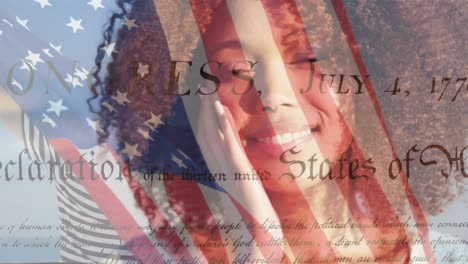 Animation-of-flag-of-united-states-of-america-over-happy-african-american-woman-on-beach
