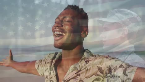 Animación-De-La-Bandera-De-Los-Estados-Unidos-De-América-Sobre-Un-Soldado-Y-Un-Hombre-Afroamericano-En-La-Playa.