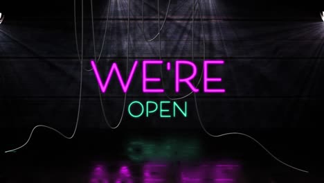 Animation-of-we're-text-in-pink-and-blue-neon-letters-on-black-background