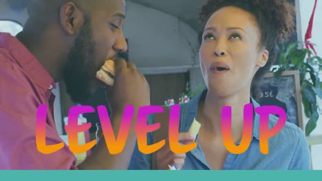 Animation-of-level-up-text-in-pink-and-orange-over-happy-african-american-couple-eating-at-cafe