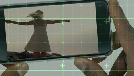 Animation-of-data-processing-over-businessman-holding-smartphone-with-woman-dancing
