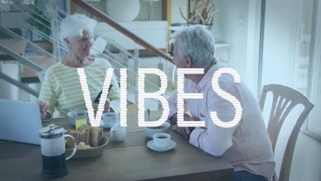 Animation-Von-Vibes-Text-In-Weiß-über-Einem-Glücklichen-Kaukasischen-Seniorenpaar,-Das-Beim-Frühstück-Einen-Laptop-Benutzt