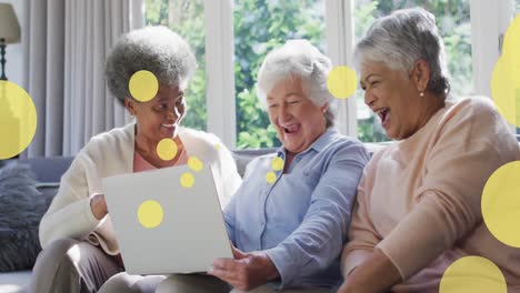 Animation-Glücklicher-älterer,-Vielfältiger-Freundinnen,-Die-Einen-Laptop-über-Hellen-Flecken-Benutzen
