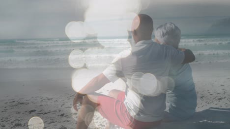 Animation-of-happy-senior-african-american-couple-embracing-at-beach-over-sea
