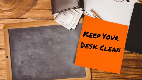 Animation-of-keep-your-desk-clean-text-on-memo-note-over-chalkboard-on-desk