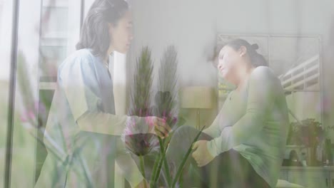 Animation-of-asian-doctor-treating-female-patient-over-plants