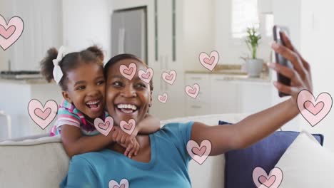 Animation-of-happy-african-american-mother-and-daughter-taking-selfie-over-hearts