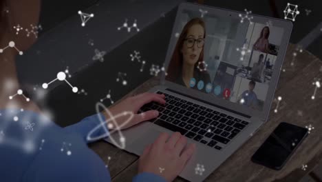 Animation-of-white-molecules-spinning-over-woman-on-laptop-video-call