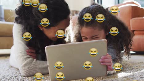 Animation-Von-Emoji-Symbolen-über-Einer-Glücklichen-Gemischtrassigen-Mutter-Und-Tochter,-Die-Einen-Laptop-Benutzen