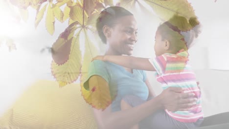Animation-Einer-Glücklichen-Afroamerikanischen-Mutter-Und-Tochter,-Die-Sich-über-Blätter-Umarmt