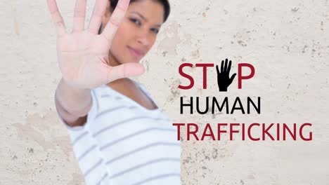 Animation-of-stop-human-trafficking-text-over-biracial-woman-with-stop-gesture