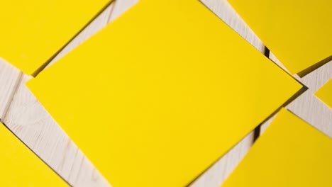 Animation-of-multiple-yellow-cards-lying-on-wooden-table