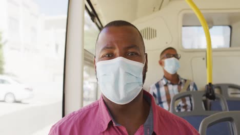 Portrait-of-afrcan-american-man-in-face-mask-sitting-on-bus