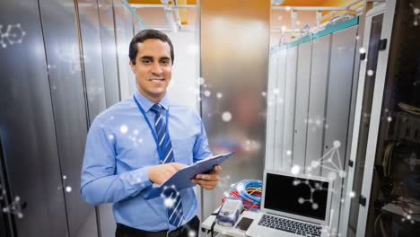 Animation-of-shapes-moving-over-smiling-biracial-male-worker-inspecting-server-room