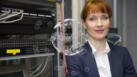 Animation-of-globe-with-icons-over-caucasian-female-worker-inspecting-server-room