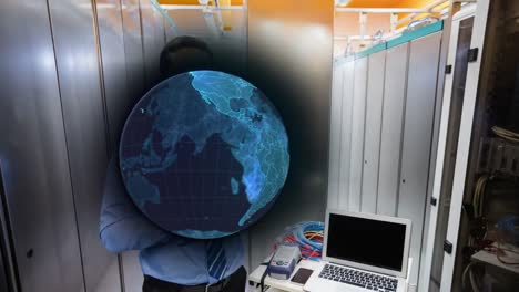 Animation-of-globe-over-smiling-biracial-male-worker-inspecting-server-room