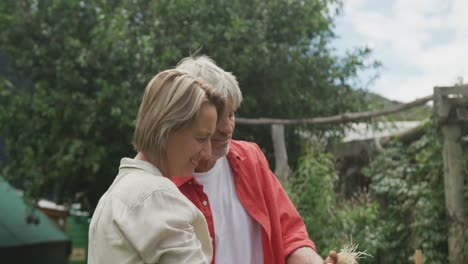 Smiling-senior-caucasian-couple-harvesting-and-working-together-in-garden