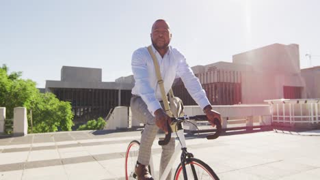 Hombre-Afroamericano-En-Bicicleta-Bajo-El-Sol-En-La-Ciudad