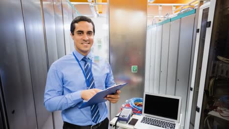 Animation-of-media-icons-over-smiling-biracial-male-worker-inspecting-server-room