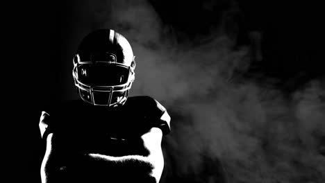 Animation-of-smoke-with-male-american-football-player-with-arms-crossed