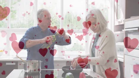Animation-of-hearts-over-happy-senior-caucasian-couple-cooking