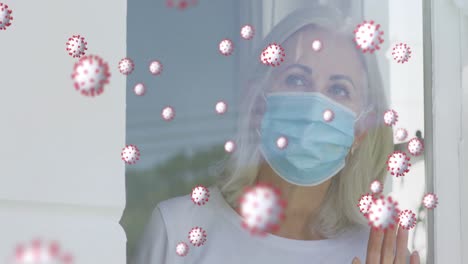 Animation-of-virus-cells-with-senior-caucasian-woman-with-face-mask