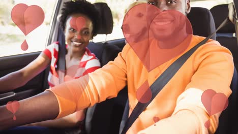 Animation-of-heart-icons-floating-over-pet-dog-and-african-american-couple-in-car
