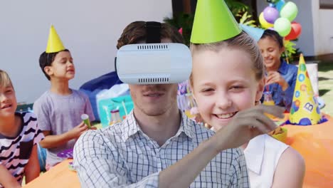 Animation-of-caucasian-man-using-vr-headset-over-diverse-children-with-party-hats-at-birthday-party