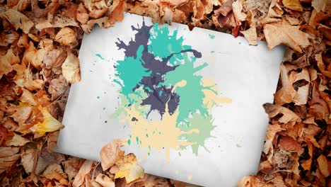 Animation-of-multiple-colorful-stains-over-white-paper-and-leaves
