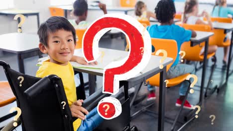 Animation-of-question-marks-over-smiling-asian-schoolboy-in-wheelchair-in-classroom