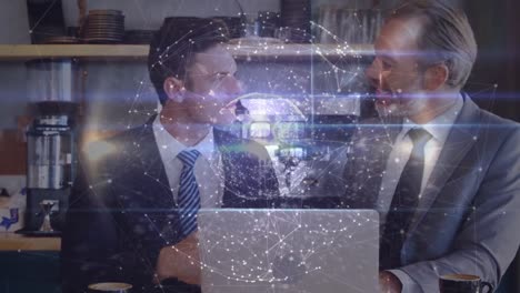 Animation-of-globe-of-connections-over-two-caucasian-businessmen-using-laptop