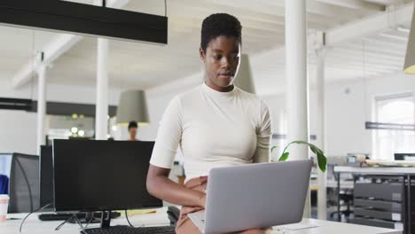Fokussierte-Afroamerikanische-Geschäftsfrau,-Die-Im-Büro-Am-Laptop-Arbeitet