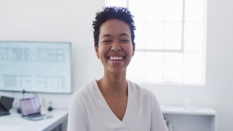 Glückliche-Afroamerikanische-Geschäftsfrau,-Die-Im-Büro-In-Die-Kamera-Blickt