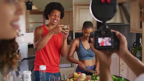 Diverse-group-of-friends-making-culinary-video-blog-in-kitchen