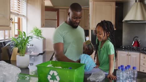 Glücklicher-Afroamerikanischer-Vater-Und-Tochter,-Die-Müll-In-Der-Küche-Recyceln