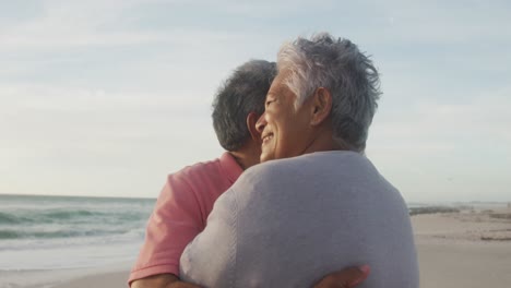 Happy-hispanic-senior-couple-dancing-on-beach-at-sunset