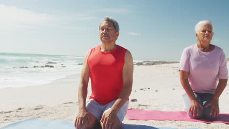 Entspanntes-Hispanisches-älteres-Paar,-Das-Yoga-Auf-Matten-Am-Strand-Praktiziert