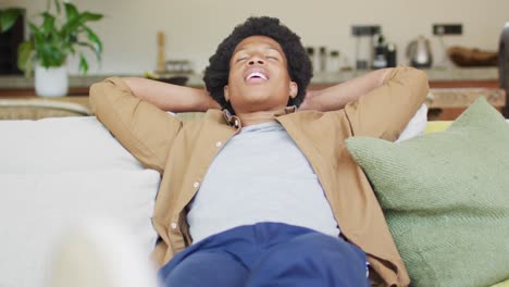 Glücklicher-Afroamerikanischer-Mann,-Der-Sich-Ausruht-Und-Entspannt-Und-Auf-Der-Couch-Sitzt