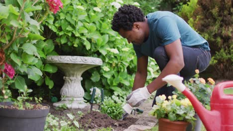 Hombre-Birracial-Feliz-Haciendo-Jardinería,-Plantando-Flores