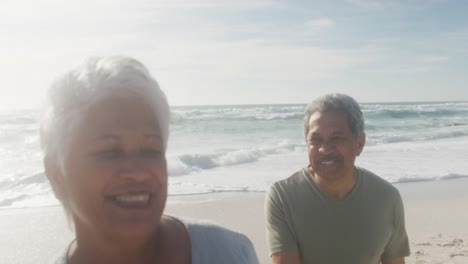 Glückliches-Hispanisches-Seniorenpaar,-Das-Bei-Sonnenuntergang-Am-Strand-Spaziert