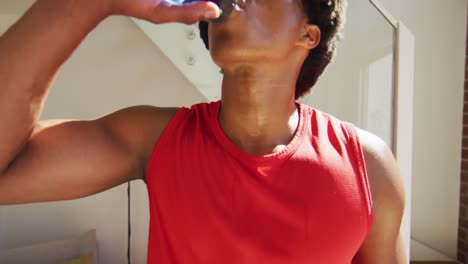 Fit-african-american-man-exercises-,and-drinking-water-at-home