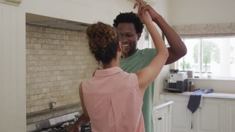 Glückliches-Gemischtrassiges-Paar,-Das-Zusammen-In-Der-Küche-Tanzt