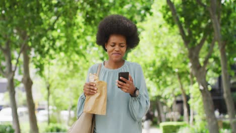 Afroamerikanische-Geschäftsfrau,-Die-Isst-Und-Smartphone-Benutzt