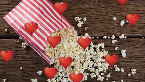 Animation-of-heart-icons-over-box-of-popcorn
