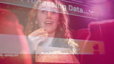 Animation-of-data-processing-over-caucasian-woman-eating-popcorn-in-cinema