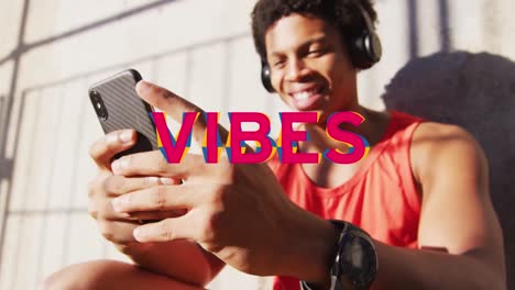 Animation-Von-Vibes-Text-über-Einem-Lächelnden-Afroamerikanischen-Mann,-Der-Sein-Smartphone-Nutzt