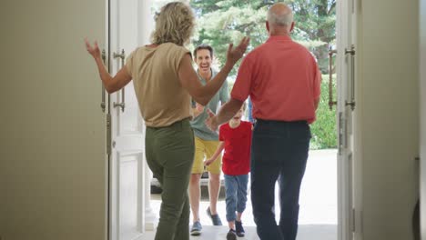 Glückliche-Kaukasische-Großeltern,-Die-Die-Tür-öffnen-Und-Ihre-Familie-Begrüßen