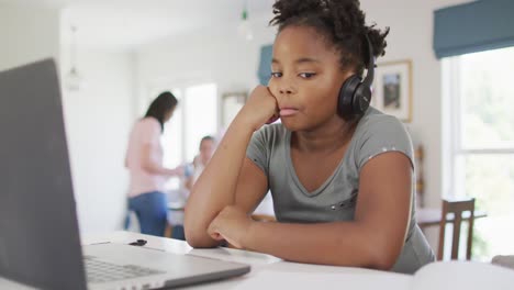Happy-african-american-girl-using-laptop-for-online-lesson-at-home