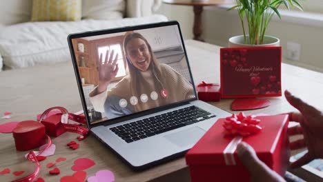Happy-caucasian-woman-waving-and-making-valentine's-day-video-call-on-laptop