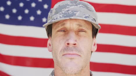 Caucasian-male-soldier-wearing-cap-and-looking-away-over-american-flag